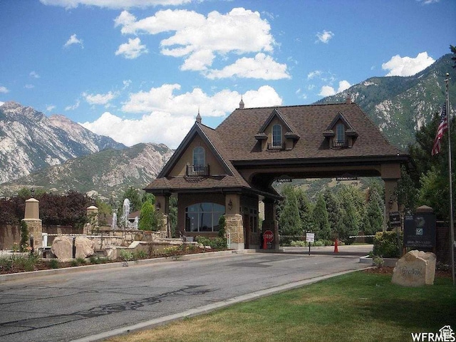 view of asphalt street featuring a mountain view and curbs
