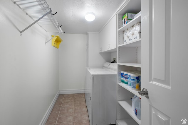 washroom featuring cabinet space, separate washer and dryer, baseboards, and light tile patterned floors
