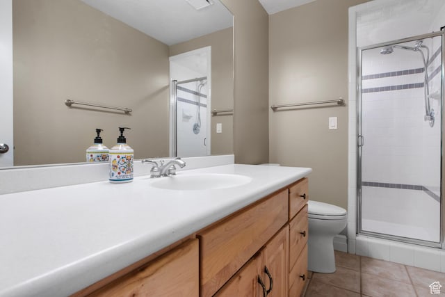 full bath with a shower stall, tile patterned floors, vanity, and toilet