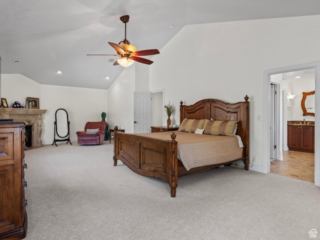 bedroom with light colored carpet, recessed lighting, baseboards, high vaulted ceiling, and ensuite bath