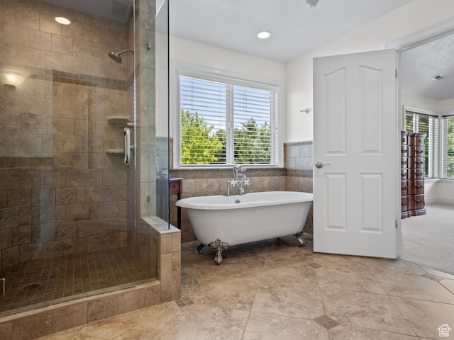 full bath with a shower stall and a soaking tub
