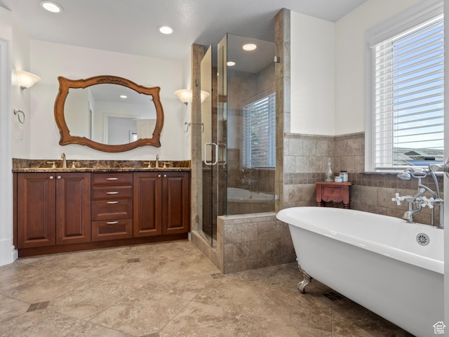 full bathroom featuring a freestanding bath, a shower stall, double vanity, wainscoting, and recessed lighting