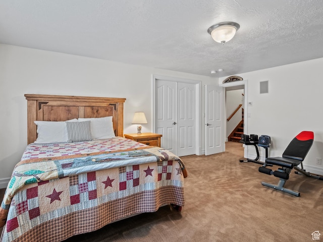 bedroom featuring a closet, carpet floors, a textured ceiling, and baseboards