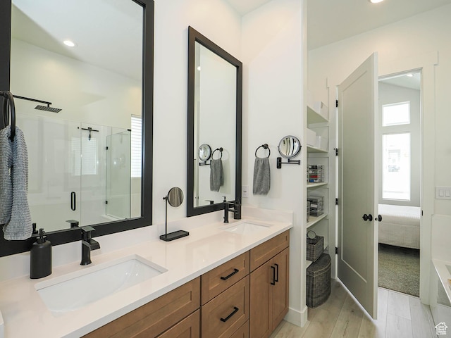 bathroom featuring a stall shower, double vanity, and recessed lighting