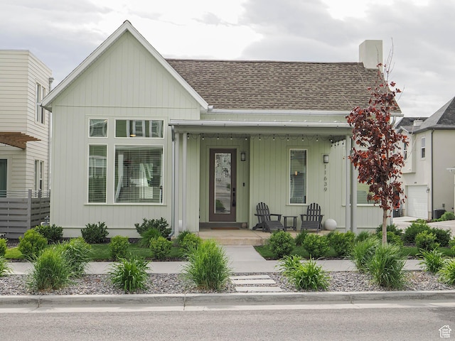 bungalow-style house with roof with shingles and a porch