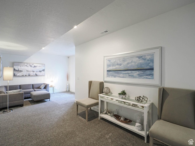 living room featuring carpet flooring, a textured ceiling, and baseboards