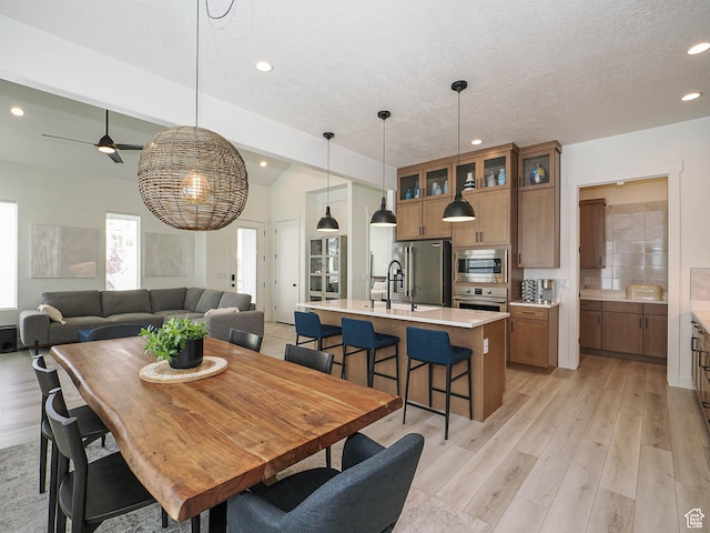 dining space featuring recessed lighting, a textured ceiling, light wood-style flooring, a ceiling fan, and lofted ceiling