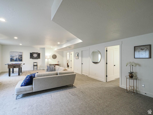 carpeted living area with recessed lighting, a textured ceiling, and baseboards