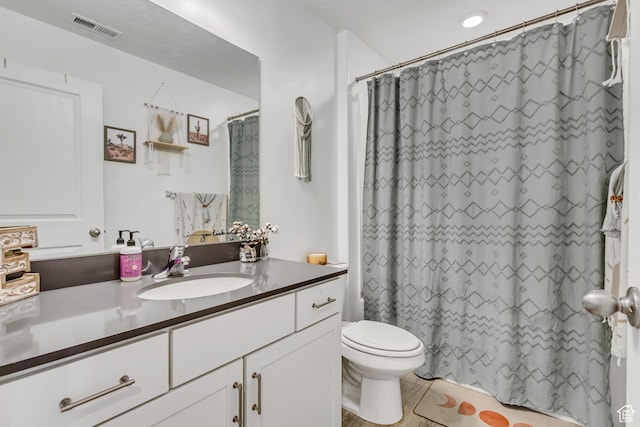 bathroom with toilet, vanity, and a shower with shower curtain