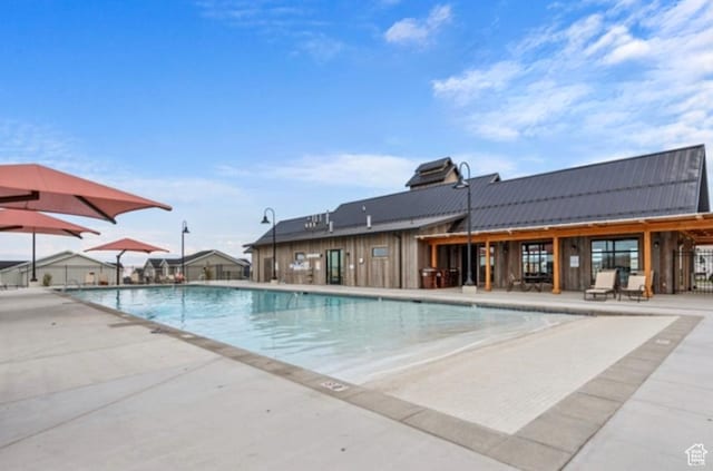 community pool with a patio and fence