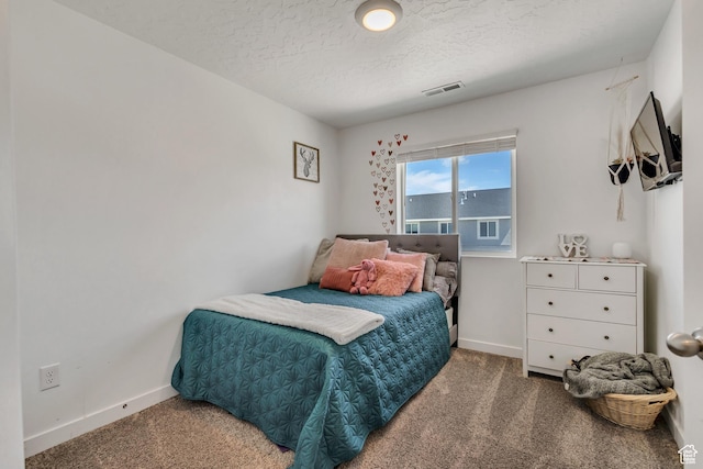 carpeted bedroom featuring baseboards and a textured ceiling