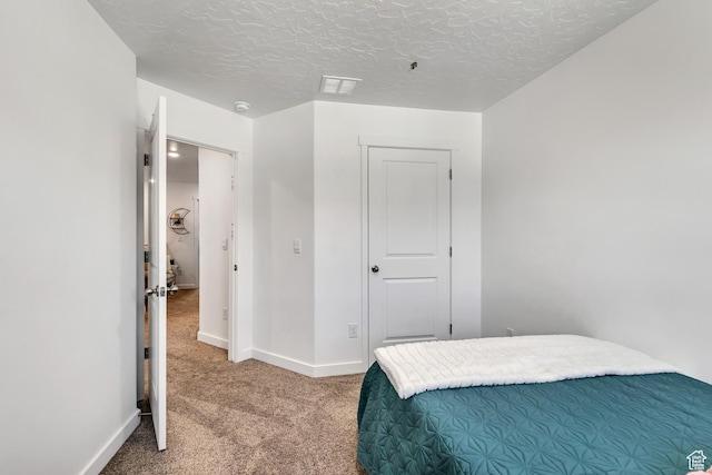 bedroom featuring carpet, baseboards, and a textured ceiling