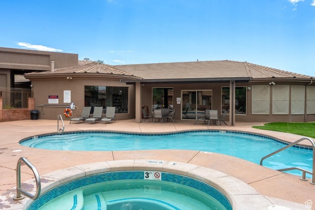 community pool featuring a patio and a community hot tub