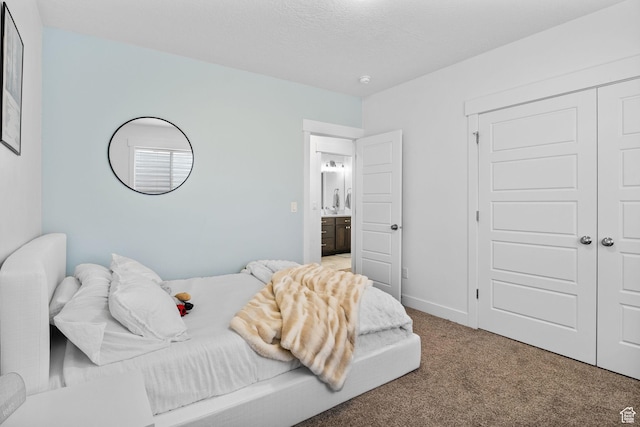 carpeted bedroom featuring a closet and baseboards
