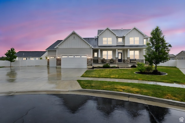 view of front of property featuring covered porch, board and batten siding, driveway, an attached garage, and stone siding
