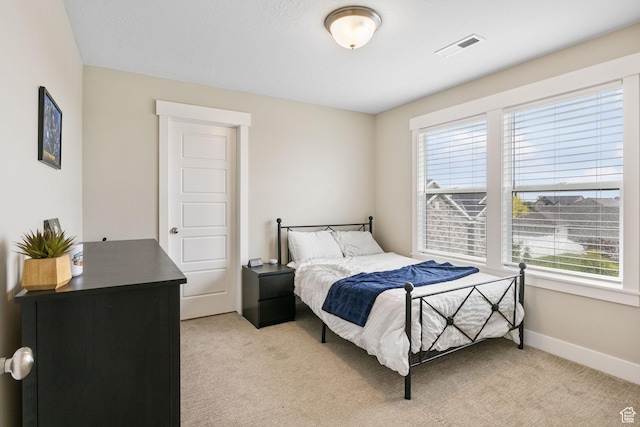 bedroom featuring light colored carpet and baseboards