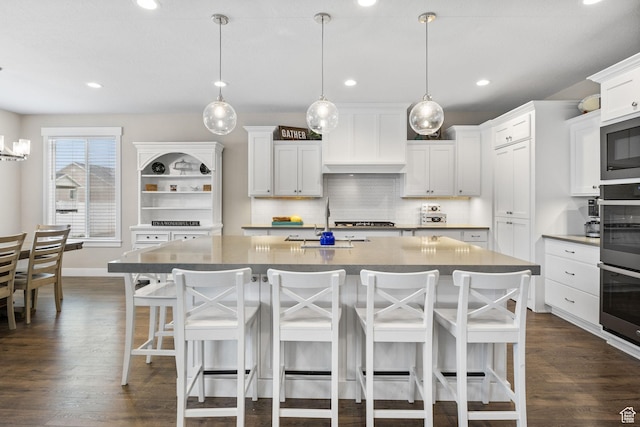 kitchen featuring stainless steel appliances, a sink, custom exhaust hood, decorative backsplash, and dark wood-style flooring