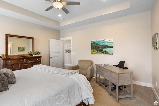 carpeted bedroom with baseboards, a tray ceiling, a desk, recessed lighting, and ceiling fan