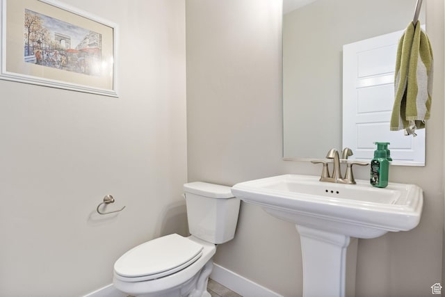 bathroom featuring baseboards and toilet