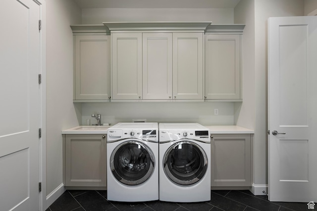 washroom featuring cabinet space, dark tile patterned flooring, separate washer and dryer, and baseboards