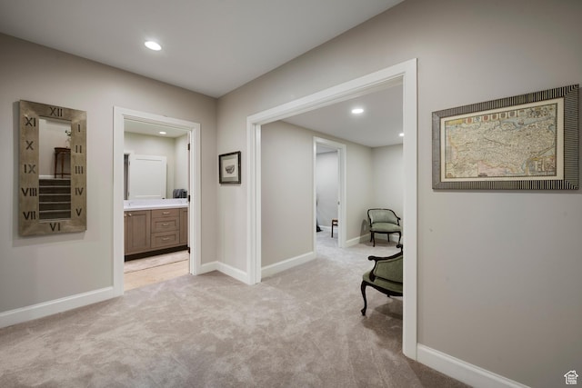 sitting room with light colored carpet, recessed lighting, and baseboards