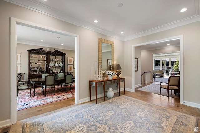 hall featuring wood finished floors, crown molding, recessed lighting, and baseboards