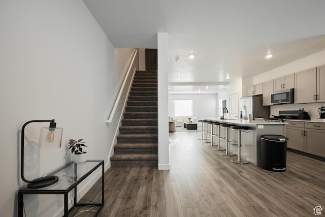 311 S 1130 W Unit 24, American Fork, UT 84003 - kitchen featuring stainless steel appliances, gray cabinetry, a breakfast bar area, dark wood-type flooring, and an island with sink