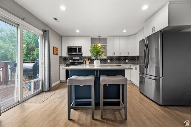 kitchen with stainless steel appliances, light countertops, white cabinets, tasteful backsplash, and recessed lighting