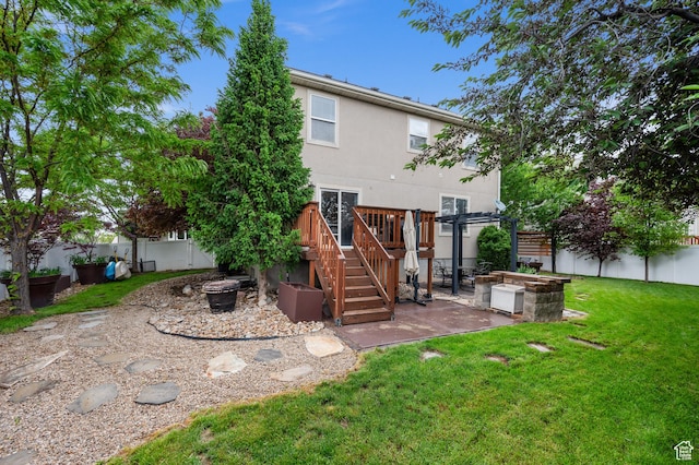 rear view of property featuring an outdoor fire pit, a patio area, stucco siding, a pergola, and a wooden deck