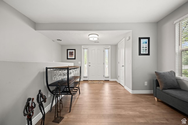 entryway with wood finished floors and baseboards