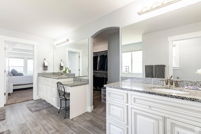 ensuite bathroom featuring wood finished floors and two vanities