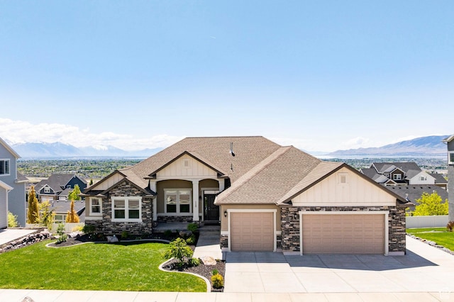 craftsman-style home with stone siding, a garage, a mountain view, and board and batten siding