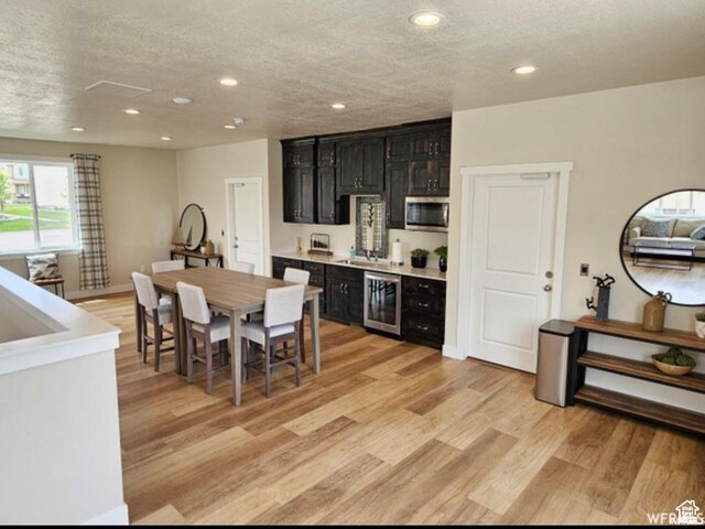 98 E 1040 N Unit 134, Santaquin, UT 84655 - kitchen featuring beverage cooler, dark cabinets, stainless steel microwave, recessed lighting, and a textured ceiling