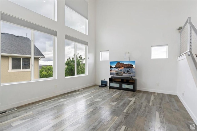 15134 S White Hart Ln, Bluffdale, UT 84065 - living room featuring wood finished floors, healthy amount of natural light, and a high ceiling
