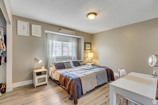 bedroom featuring light wood finished floors and baseboards