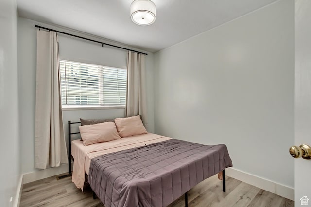 bedroom featuring light wood-style floors and baseboards