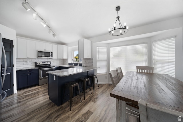 6507 S Silver Medal Dr, Taylorsville, UT 84129 - kitchen featuring stainless steel appliances, a breakfast bar area, white cabinets, a chandelier, and a sink