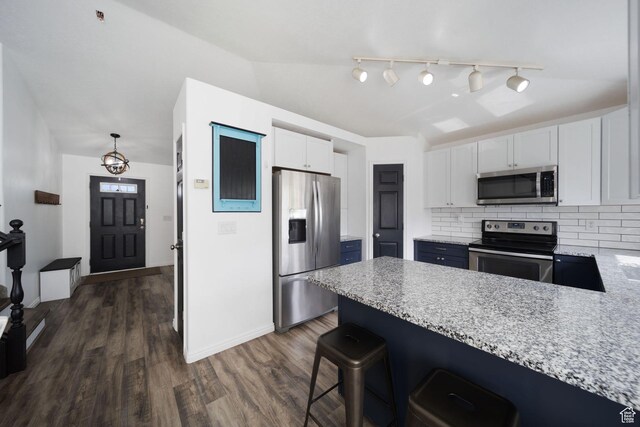 6507 S Silver Medal Dr, Taylorsville, UT 84129 - kitchen with stainless steel appliances, a peninsula, white cabinets, backsplash, and dark wood-style flooring