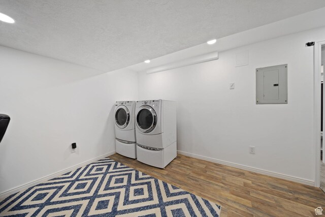 6507 S Silver Medal Dr, Taylorsville, UT 84129 - washroom featuring electric panel, washer and clothes dryer, wood finished floors, baseboards, and a textured ceiling