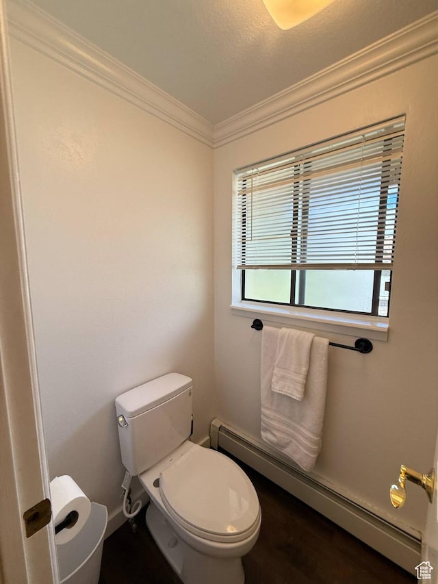bathroom featuring a baseboard heating unit, toilet, ornamental molding, wood finished floors, and baseboards