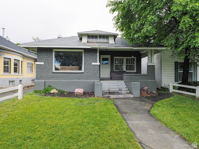 466 N 200 E, Provo, UT 84606 - bungalow featuring a front yard, brick siding, covered porch, and roof with shingles