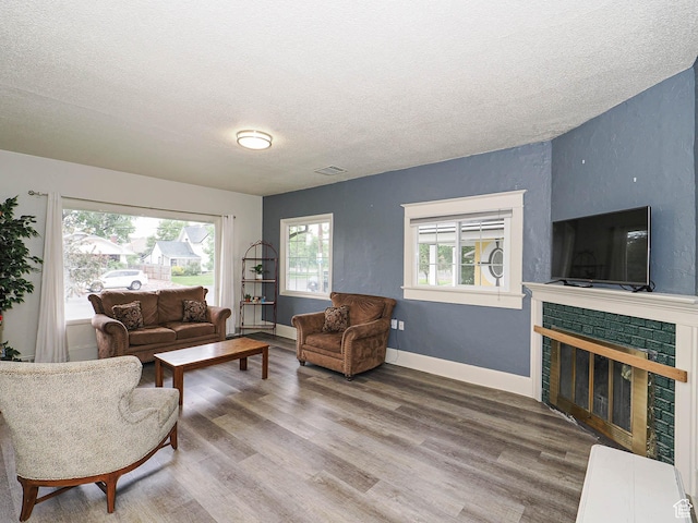466 N 200 E, Provo, UT 84606 - living area featuring a textured ceiling, wood finished floors, and a brick fireplace