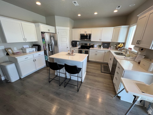 1297 W 450 N, Springville, UT 84663 - kitchen with stainless steel appliances, a kitchen island, white cabinets, dark wood-style flooring, and recessed lighting