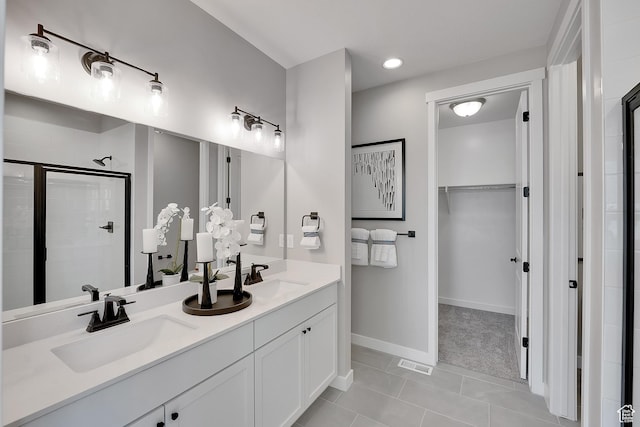 4053 W 2025 S Unit 40, Taylor, UT 84401 - bathroom with a shower stall, a walk in closet, tile patterned floors, baseboards, and double vanity