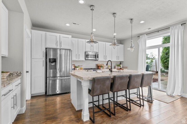 2258 W Falconer Cir, Farmington, UT 84025 - kitchen featuring appliances with stainless steel finishes, dark wood-style flooring, recessed lighting, light stone counters, and white cabinetry