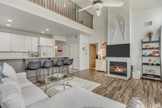 6641 N 2200 W Unit D-304, Park City, UT 84098 - living area featuring light wood-style flooring, a high ceiling, a ceiling fan, recessed lighting, and a fireplace