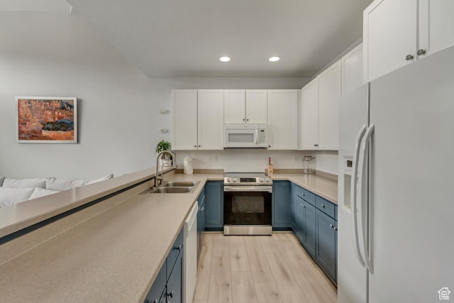 6641 N 2200 W Unit D-304, Park City, UT 84098 - kitchen with white appliances, blue cabinetry, a sink, recessed lighting, and white cabinets