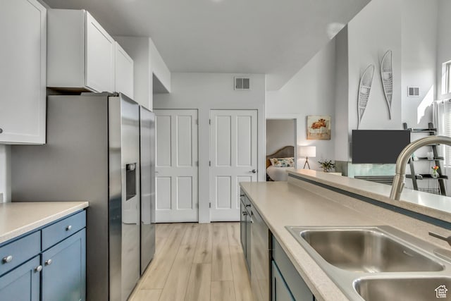 6641 N 2200 W Unit D-304, Park City, UT 84098 - kitchen featuring stainless steel appliances, light wood-style flooring, light countertops, and blue cabinetry
