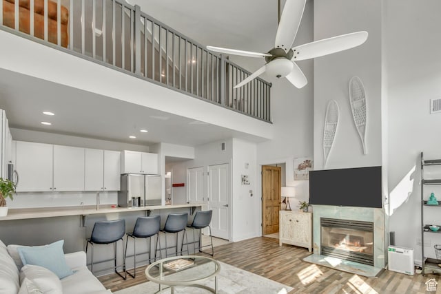 6641 N 2200 W Unit D-304, Park City, UT 84098 - living area with a towering ceiling, light wood finished floors, recessed lighting, a ceiling fan, and a tile fireplace