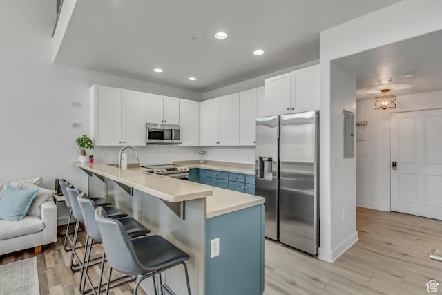 6641 N 2200 W Unit D-304, Park City, UT 84098 - kitchen with stainless steel appliances, a peninsula, a kitchen bar, light countertops, and recessed lighting